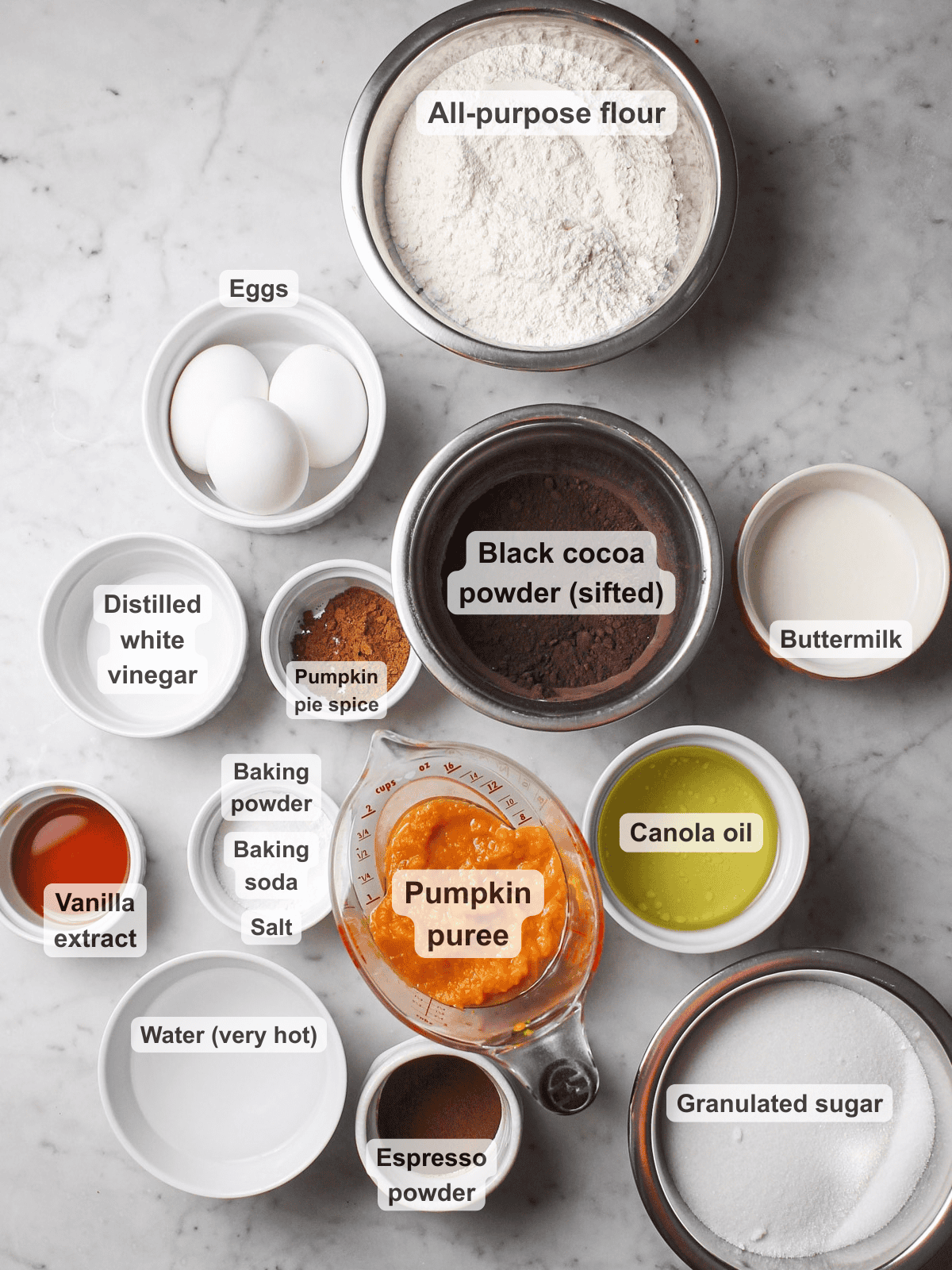 Labeled ingredients for marbled pumpkin Bundt cake, including black cocoa powder and pumpkin puree.